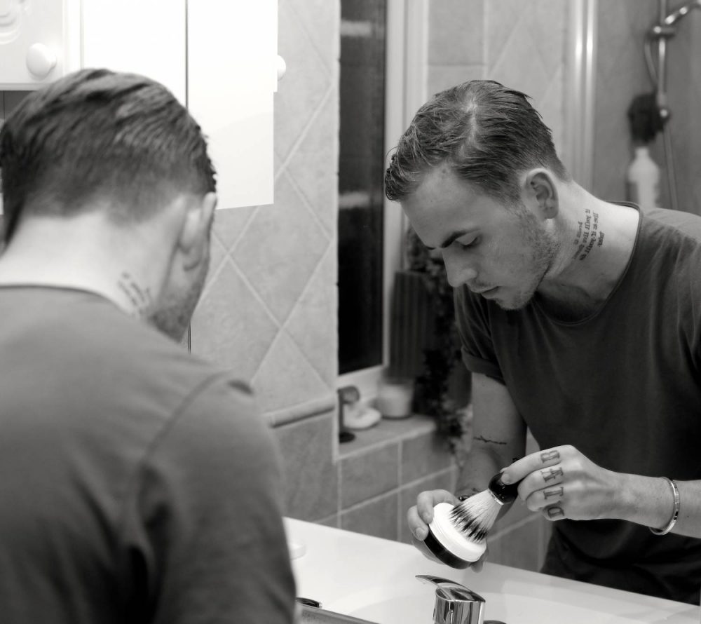 man preparing shaving lather with shaving brush