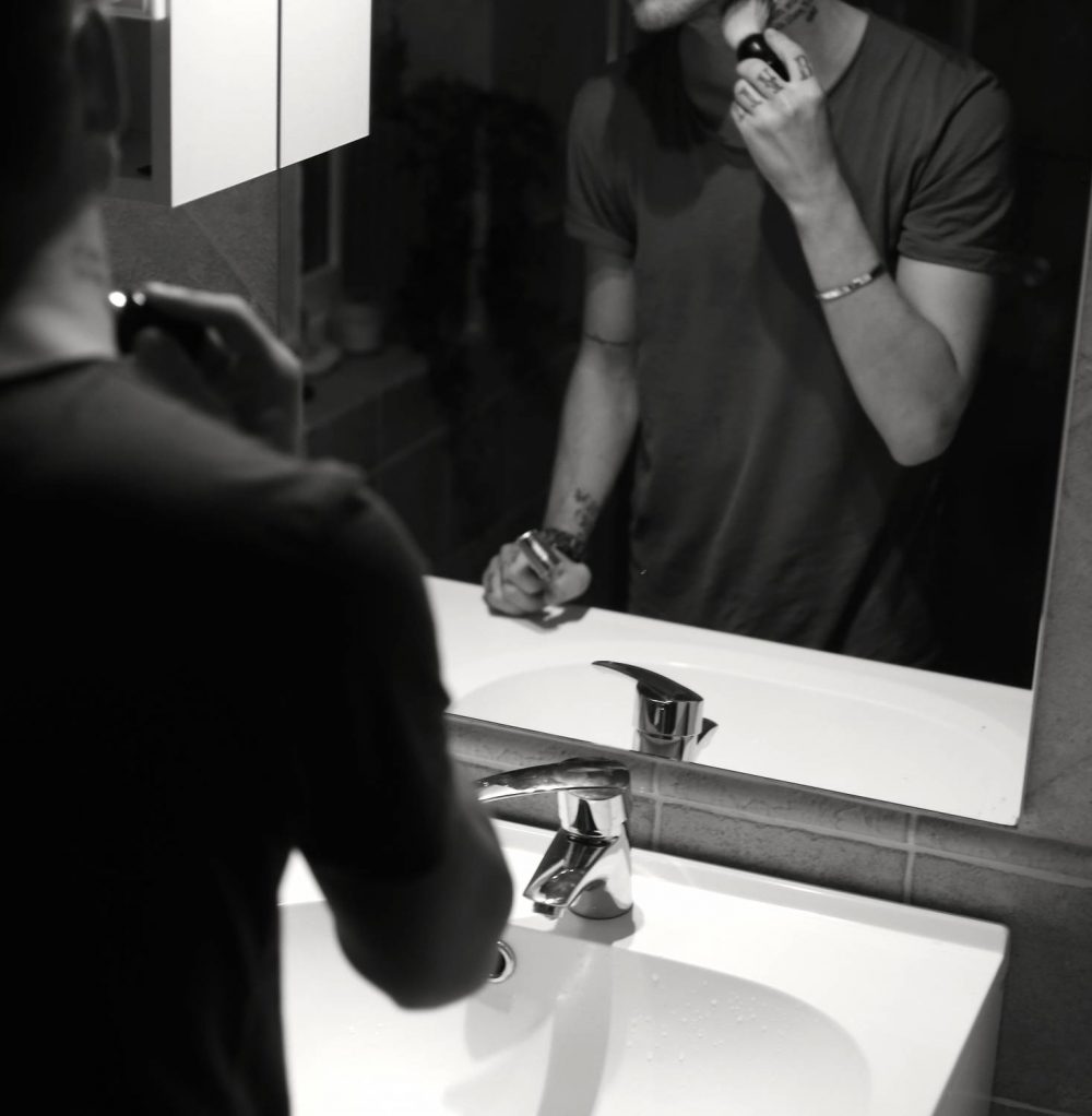 man using shaving brush on skin